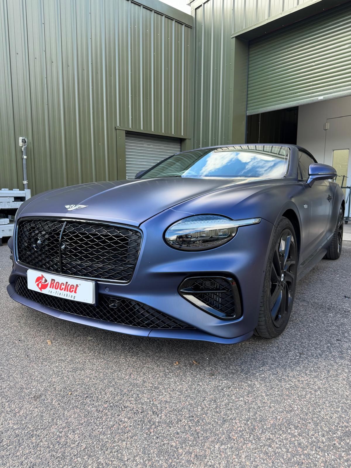 Bentley Continental with a fresh matte blue respray outside the workshop