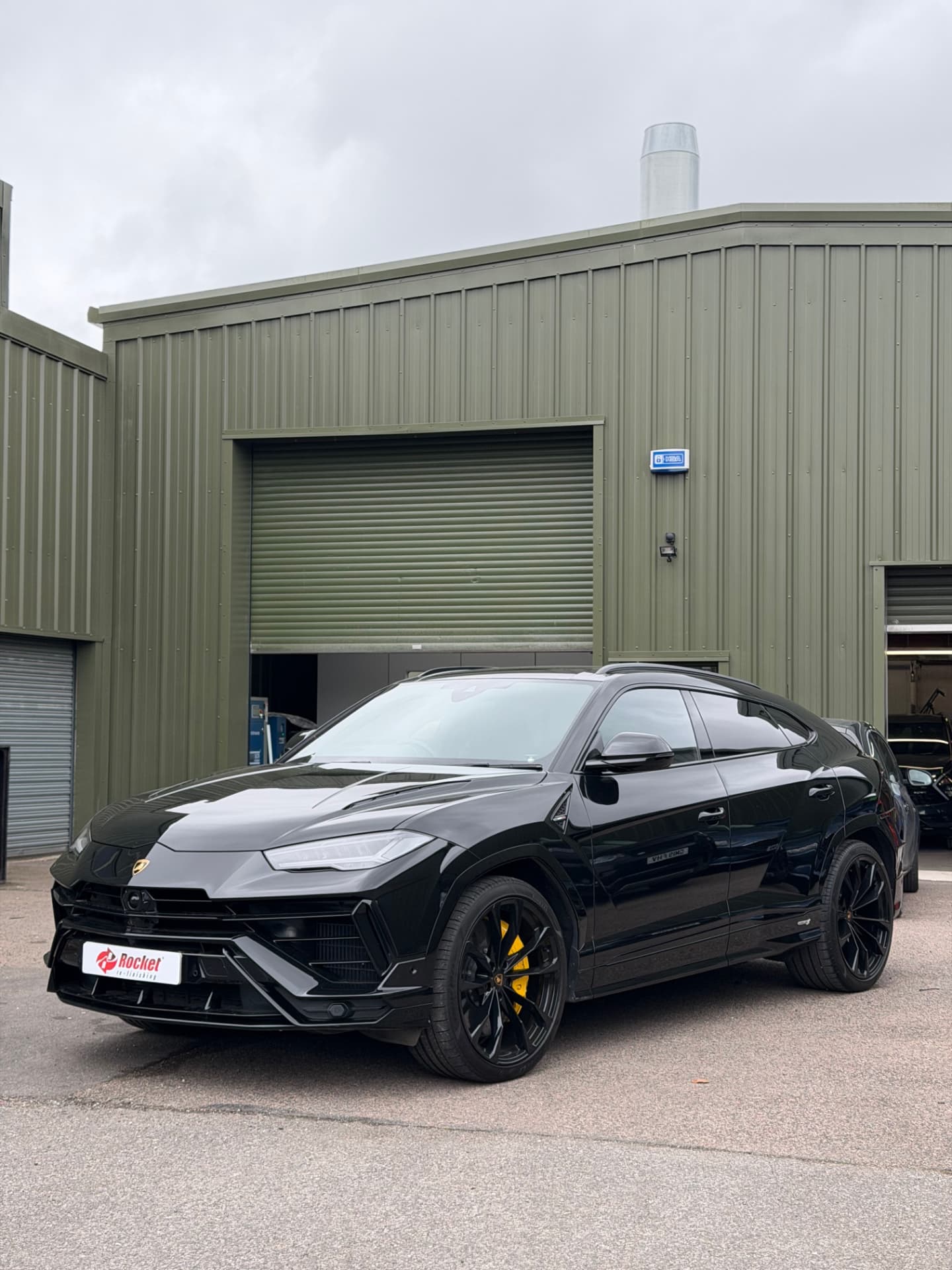 Black Lamborghini Urus with refreshed paintwork outside the workshop