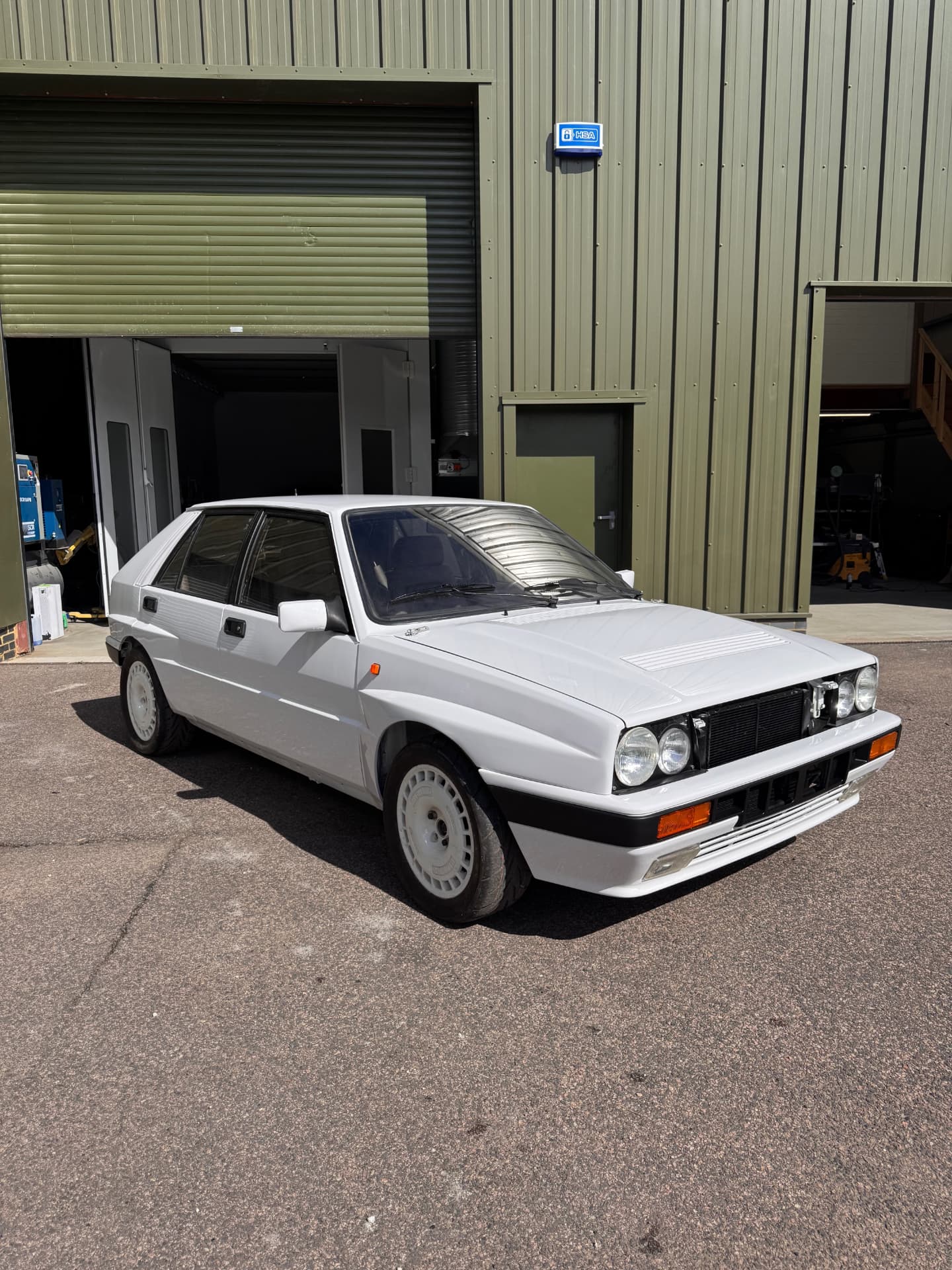 White Lancia Delta Integrale freshly resprayed outside the workshop